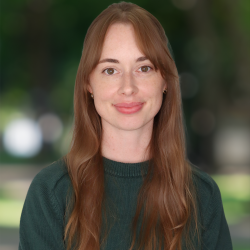 Headshot of Heather Sawyer, subject is smiling with a green background